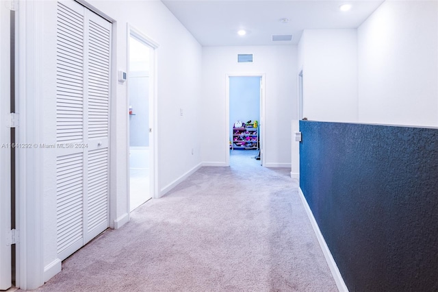 hall featuring baseboards, visible vents, light colored carpet, and recessed lighting