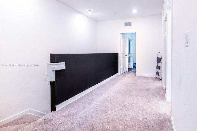 interior space with baseboards, visible vents, and light carpet