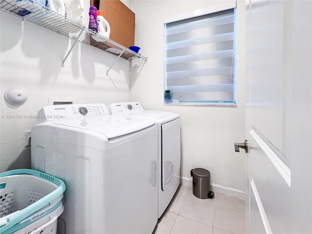 washroom with light tile patterned flooring, baseboards, laundry area, and separate washer and dryer