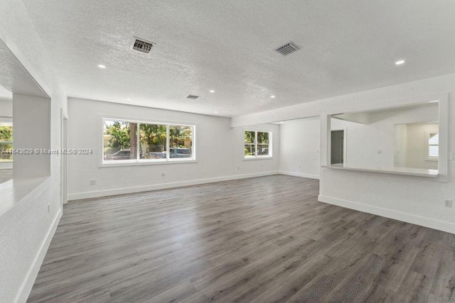 unfurnished living room featuring a textured ceiling and dark wood-type flooring