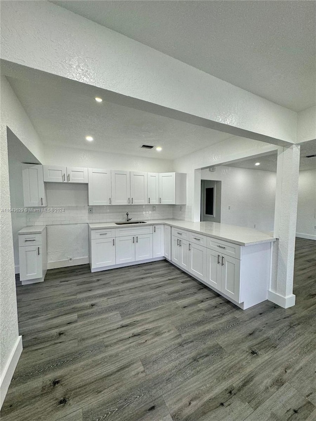 kitchen with sink, dark wood-type flooring, white cabinets, and a textured ceiling