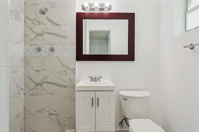 bathroom featuring vanity, toilet, and a tile shower