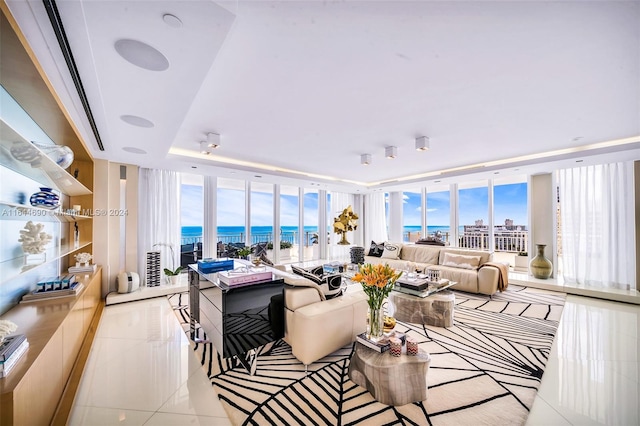 tiled living room with expansive windows, plenty of natural light, and a water view