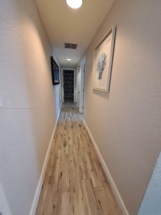 corridor with light hardwood / wood-style flooring