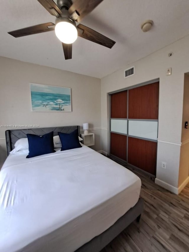 bedroom with ceiling fan and dark hardwood / wood-style flooring