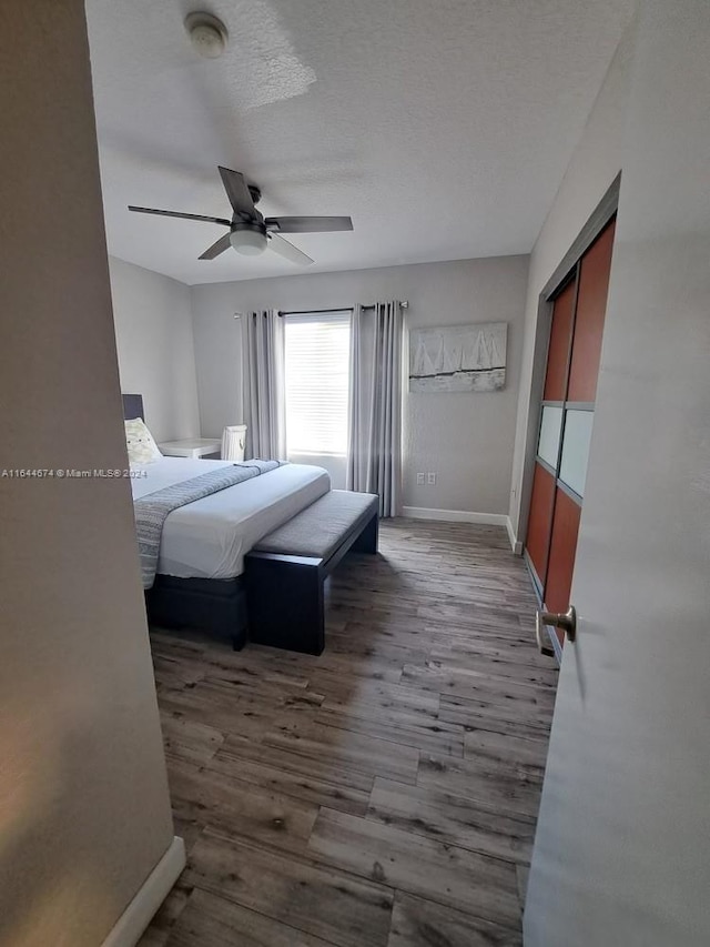 bedroom featuring ceiling fan, a textured ceiling, and wood-type flooring