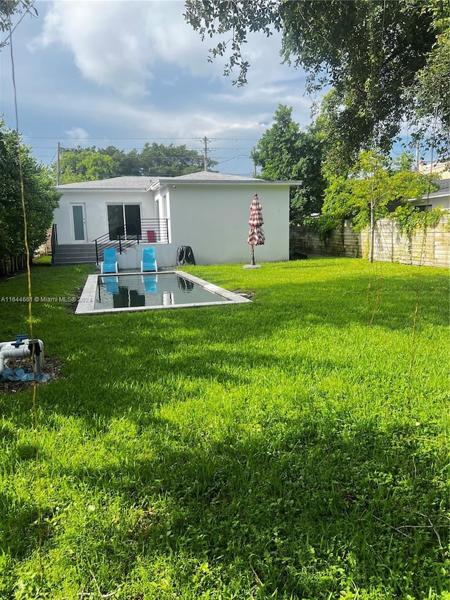 back of house with a patio and a yard