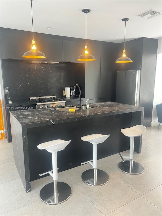 kitchen featuring decorative backsplash, a breakfast bar, and hanging light fixtures