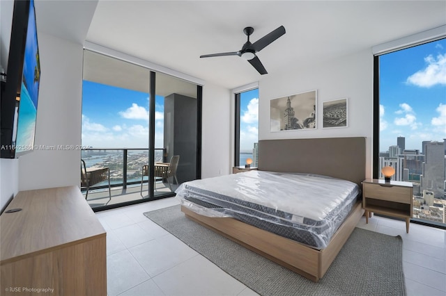 bedroom with floor to ceiling windows, a water view, ceiling fan, and access to outside