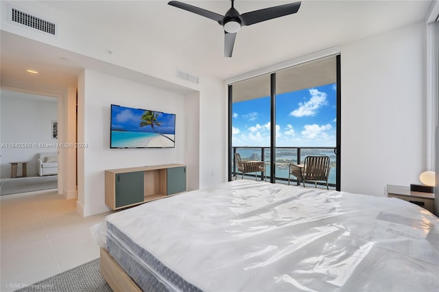 tiled bedroom featuring access to outside, ceiling fan, and expansive windows