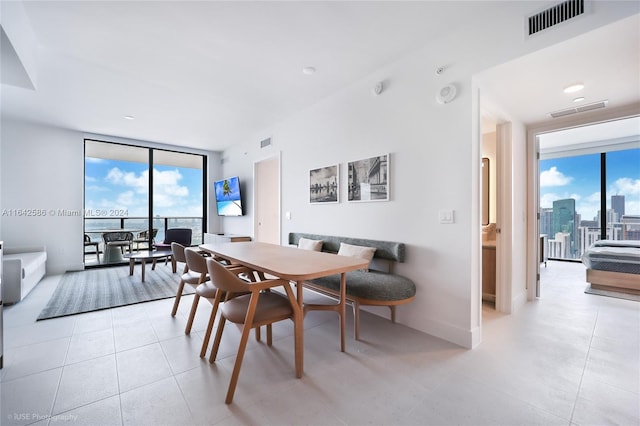 dining space featuring a wall of windows and a healthy amount of sunlight