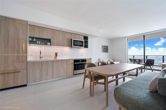 dining space featuring light tile patterned floors and sink