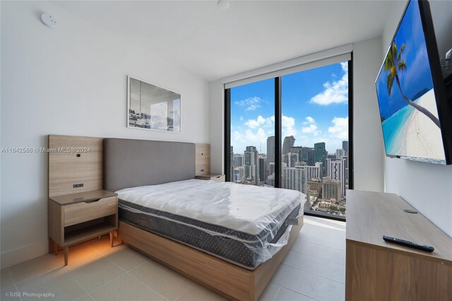 bedroom with a wall of windows, access to exterior, and multiple windows