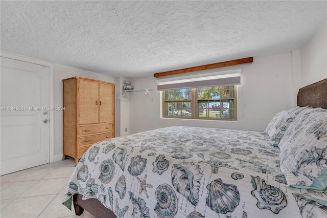 tiled bedroom featuring a textured ceiling