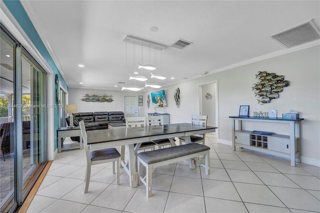 dining space featuring a notable chandelier, a textured ceiling, light tile patterned floors, and ornamental molding