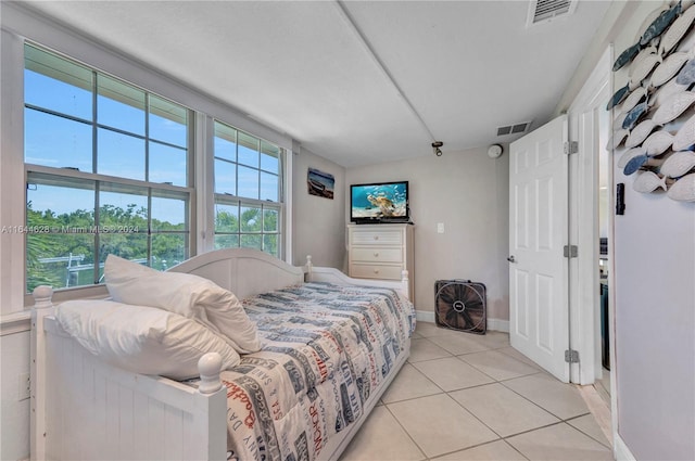 tiled bedroom featuring multiple windows