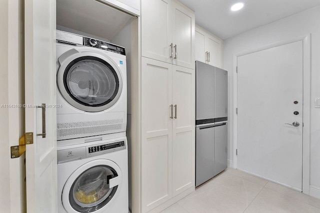 washroom featuring stacked washer / drying machine and light tile patterned flooring