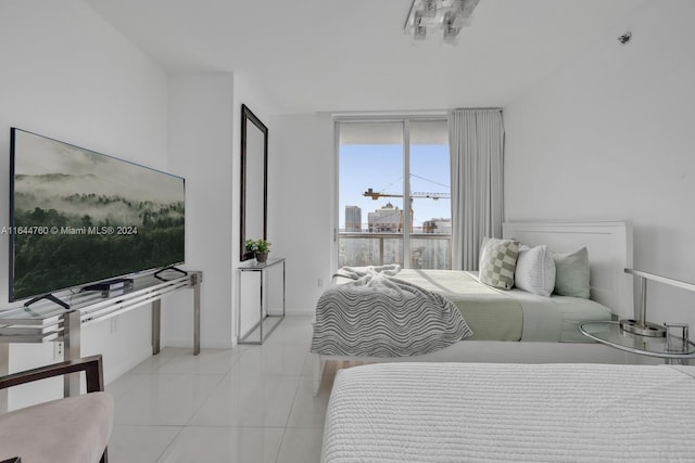 tiled bedroom featuring baseboards and expansive windows