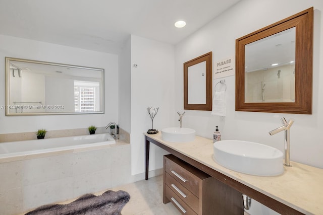 bathroom with tile patterned floors, double vanity, and a relaxing tiled tub