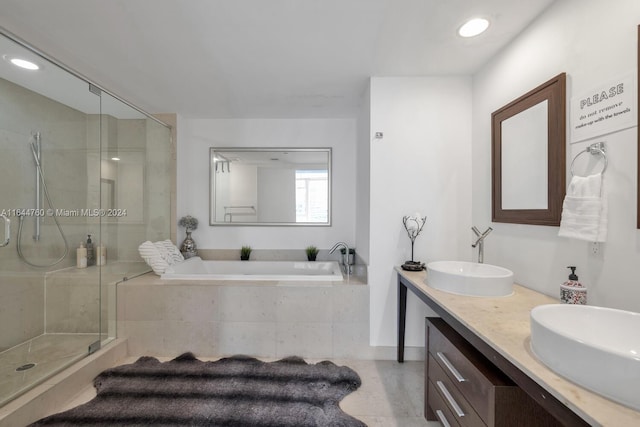 bathroom with a bath, a stall shower, and a sink