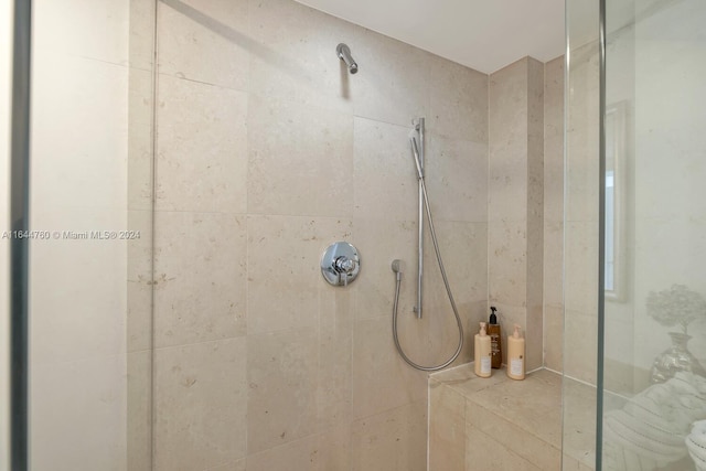 bathroom with a tile shower and toilet