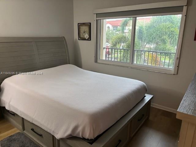 bedroom with multiple windows and wood-type flooring