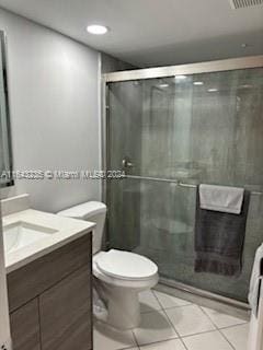 bathroom with tile patterned floors, vanity, walk in shower, and toilet