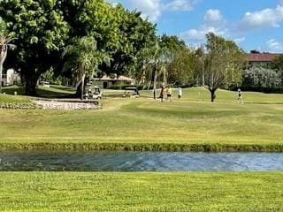 view of community with a lawn and a water view