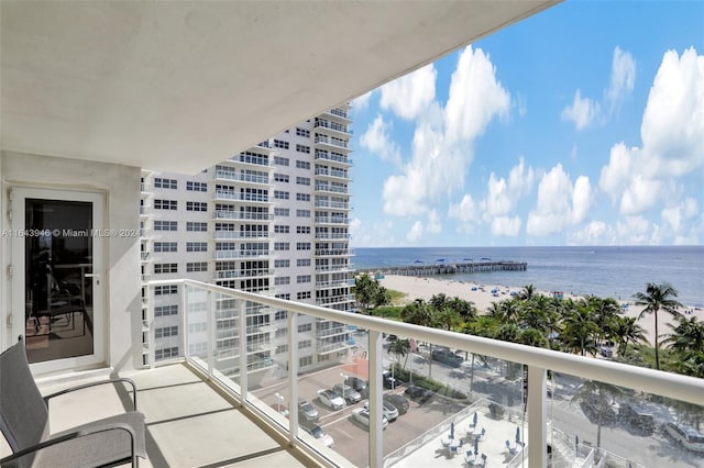 balcony with a water view and a view of the beach