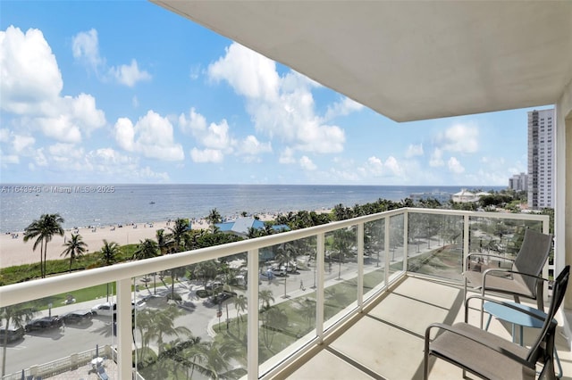 balcony featuring a beach view and a water view