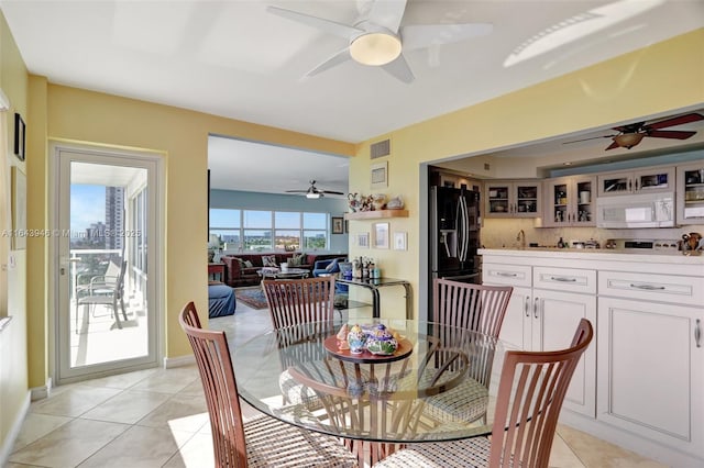 dining space with light tile patterned flooring, visible vents, and baseboards