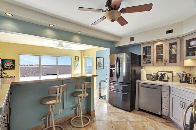 kitchen with decorative backsplash, light tile patterned floors, double oven range, and white cabinetry