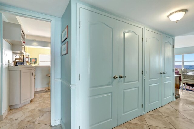 kitchen with light stone counters, double oven range, decorative backsplash, white cabinetry, and sink