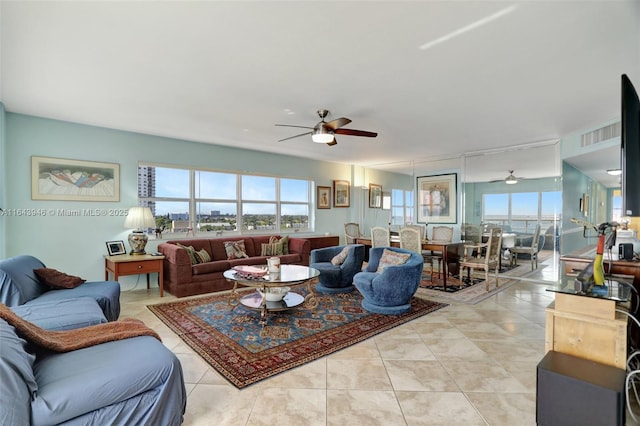 living area featuring a healthy amount of sunlight, ceiling fan, and light tile patterned floors