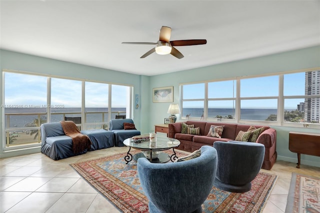 living room featuring light tile patterned floors, ceiling fan, and baseboards