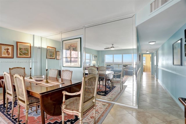 dining space featuring light tile patterned floors, ceiling fan, visible vents, and baseboards