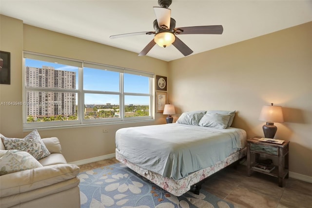 bedroom with tile patterned flooring, baseboards, a city view, and a ceiling fan