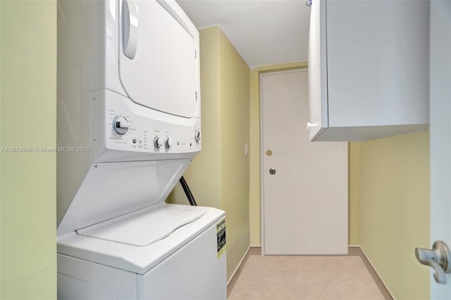 laundry room with stacked washer / dryer, cabinet space, and light colored carpet