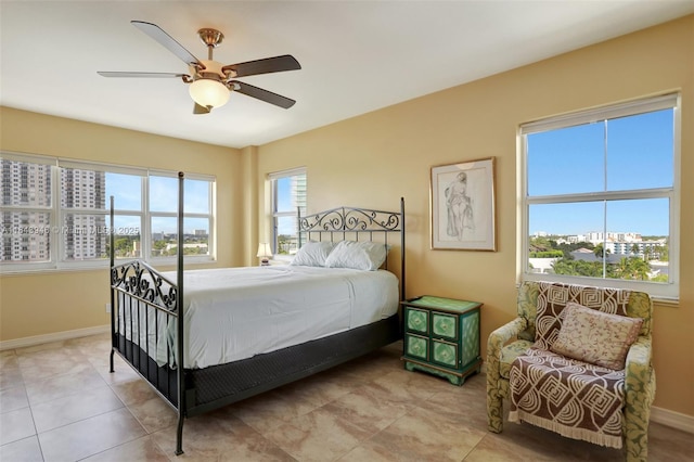 tiled bedroom with a ceiling fan and baseboards