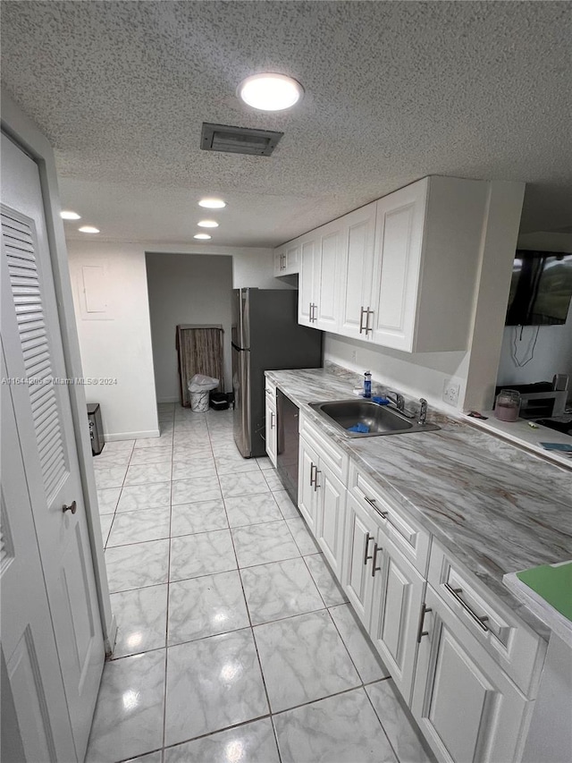 kitchen with sink, a textured ceiling, white cabinets, black dishwasher, and light tile patterned flooring