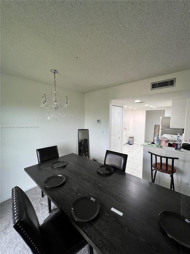 tiled dining space with an inviting chandelier and a textured ceiling