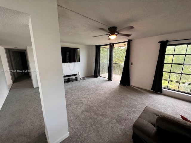 unfurnished living room with a textured ceiling, carpet flooring, and ceiling fan