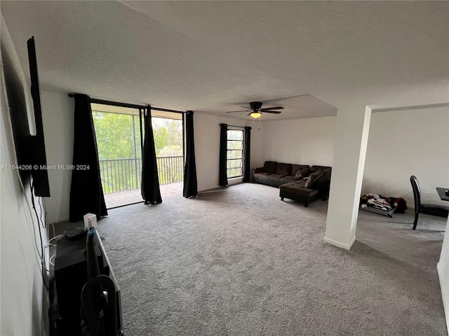 living room featuring ceiling fan, a textured ceiling, and carpet flooring