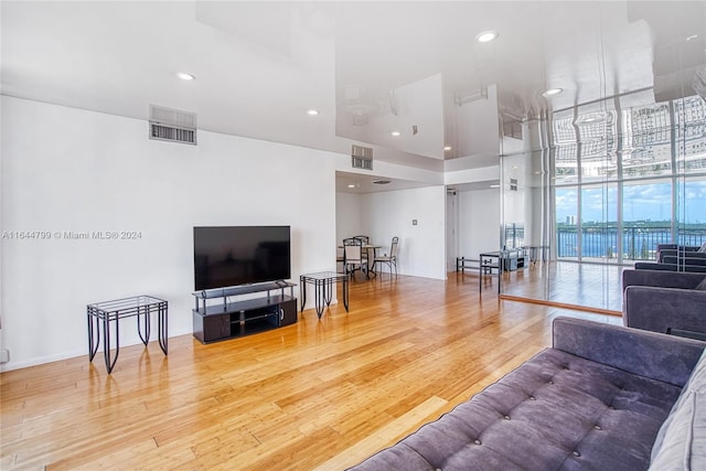 living room with light hardwood / wood-style flooring and a wall of windows