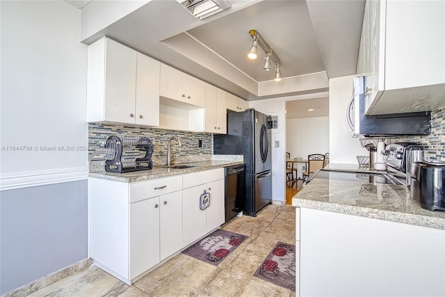 kitchen featuring sink, tasteful backsplash, track lighting, and white cabinets