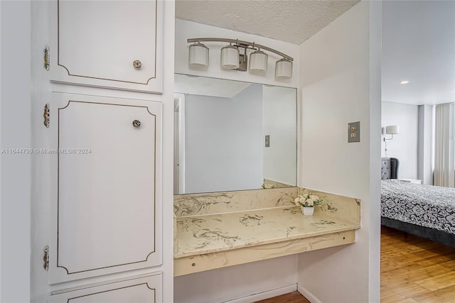 bathroom with hardwood / wood-style flooring and a textured ceiling