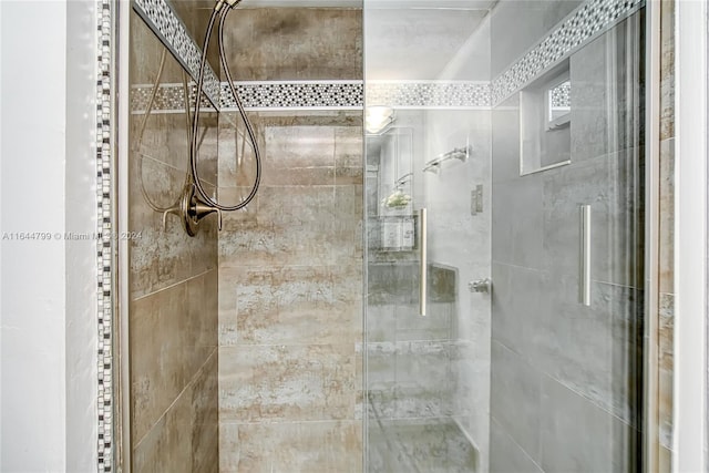 bathroom featuring a shower with shower door