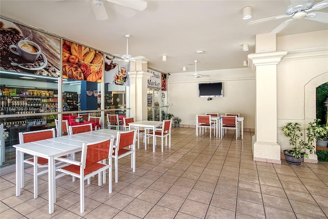 dining space featuring ceiling fan, light tile patterned flooring, and ornate columns