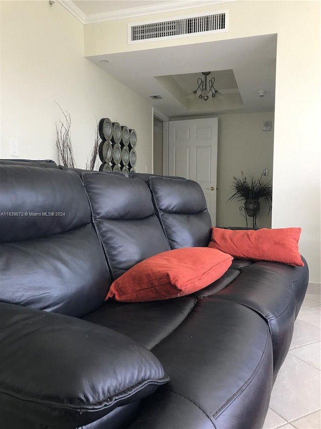 tiled living room with crown molding and a tray ceiling