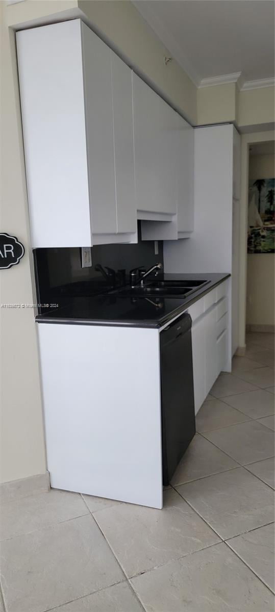 kitchen featuring ornamental molding, white cabinetry, dishwasher, and sink